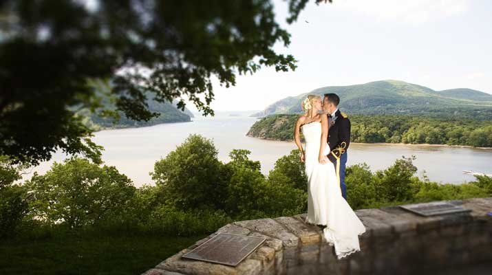 Bride and Groom standing on rock wall