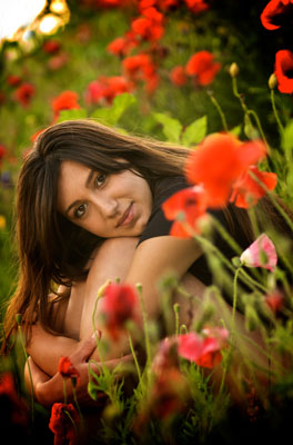 Beautiful girl sitting among the roses